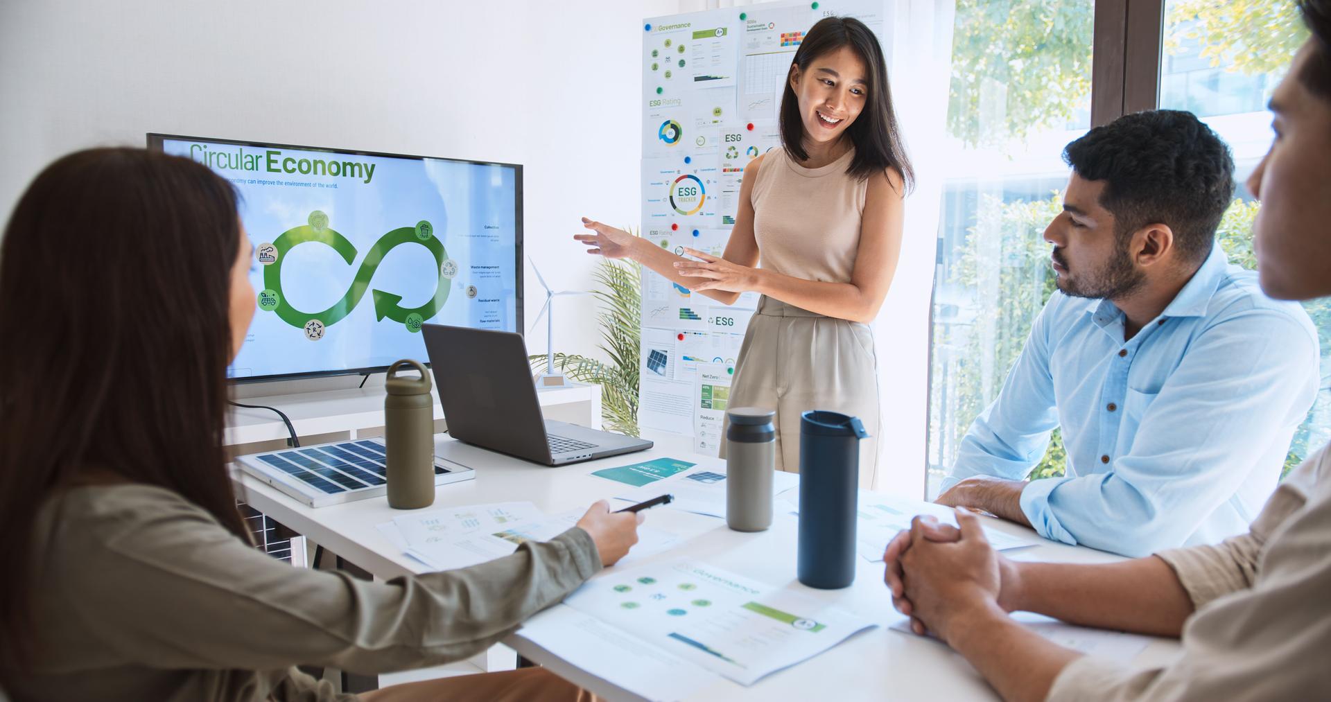 Asian woman lead young group of multiethnic businesspeople in team meeting, using laptop computer for ESG topic presentation on monitor. Sustainable business practice, people work at home concept